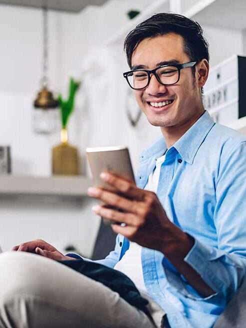 smiling young male holing a phone